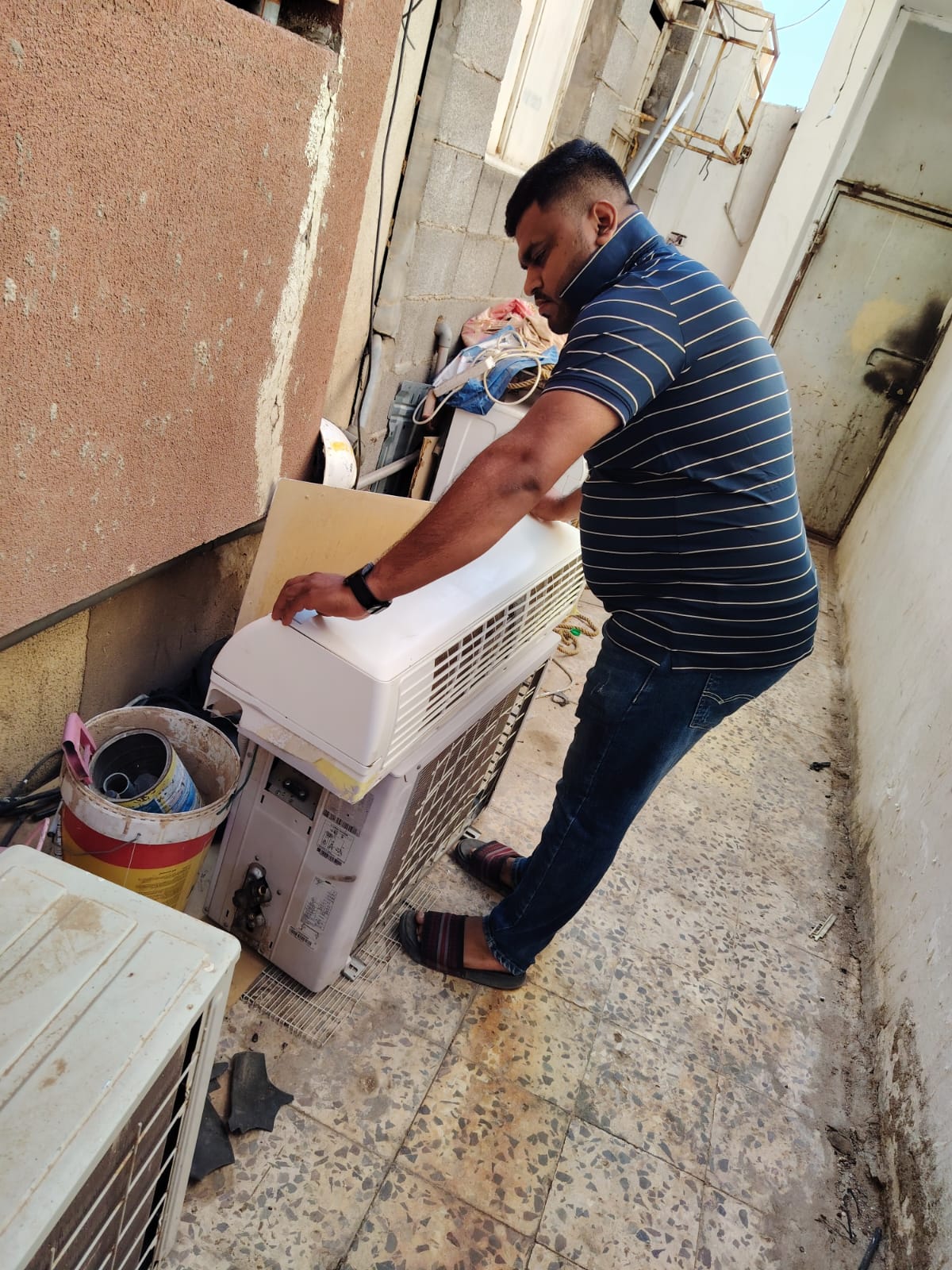 الفني محمد يقوم بفحص وصيانة المكيف